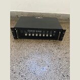 Černý basový zesilovač v rackovém provedení s nápisem CARVIN B1500 BASS AMPLIFIER. Přední panel obsahuje několik ovládacích knoflíků, přepínačů a vst…