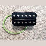 Černý humbucker s dvěma řadami šesti stříbrných pólů. K snímači vede zelený izolovaný kabel. Povrch je hladký a černý, bez viditelných značek, log ne…
