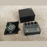 Na fotografii je kytarový efekt pedál stříbrné barvy s nápisem MICROTUBES X ULTRA a textem DARKGLASS ELECTRONICS MADE IN FINLAND. Zařízení má čtyři č…