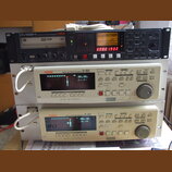 Tři stohované rackové jednotky značky Fostex. Horní zařízení je černý DVD MULTITRACK RECORDER s označením DV824, který má v displeji nápis No files!-…