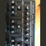 Detailní pohled na ovládací panel efektového procesoru Boss ME-80 Guitar Multiple Effects. Zařízení má černý povrch s bílými nápisy a stříbrnými otoč…
