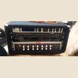 Černý rack s třemi zařízeními. Horní jednotka nese nápisy E-MAJOR a tc electronic, prostřední je kytarový zesilovač s nápisy TUBE PREAMP 530 modern R…