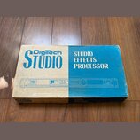 Kartonová krabice s modro-bílým potiskem. Na horní části je nápis Digitech STUDIO a STUDIO EFFECTS PROCESSOR. V prostřední části je znázorněn přístro…