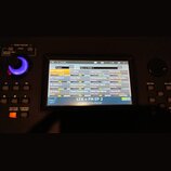 Detailní pohled na displej digitálního klaviru nebo syntezátoru. Na obrazovce je zobrazeno menu s názvem Live Set a seznam presetů v rámci kategorie…