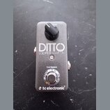 Stříbrný kytarový pedál s nápisy DITTO LOOPER a true bypass. V horní části je černý ovládací knoflík s popiskem level a v dolní části stýpací spínač.…