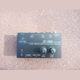 Černý kompaktní sluchátkový zesilovač s nápisy behringer a MicroMON MA400. Na předním panelu je text ULTRA-COMPACT MONITOR HEADPHONE AMPLIFIER, kontr…