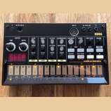 Černý elektronický drum machine s nápisem KORG a modelem volta beats. Zařízení obsahuje červený digitální displej, řadu bílých tlačítek a ovládacích…