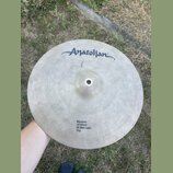 Kruhový činel z kovaného kovu s viditelným rýhováním povrchu. V horní části je nápis Anatolian a v dolní části text Emotion 14"/35cm Hi-Hat Light Top…
