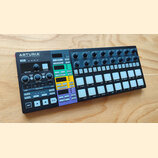 Černý sekvencer značky ARTURIA s nápisem YOUR EXPERIENCE - YOUR SOUND. Zařízení obsahuje několik otočných potenciometrů, bílá tlačítka v mřížce a bar…