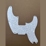 Bílý pickguard s perleťovým vzorem pro elektrickou kytaru. Díl má specifický asymetrický tvar s vyřezanými otvory pro šrouby. Povrch je hladký a bez…