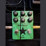 Zelený kytarový pedál s nápisy Blackstar, LT DUAL. Obsahuje šest černých otočných ovladačů s popisky CH 1 GAIN, H 2 GAIN, TONE, CH 1 LEVEL, H 2 LEVEL…