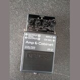 Šedý kytarový pedál s nápisy Amp & Cabinet a IR-2. Na horní části jsou čtyři ovládací knoflíky s popisky BASS, MIDDLE, TREBLE a RFRIER, kontrolka CHE…