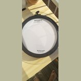 Fotografie znázorňuje elektronický bicí pad bílé barvy s černým obručováním. Na povrchu jsou nápisy „Roland“, „V-Drums“ a text „Registered in U.S. Pa…