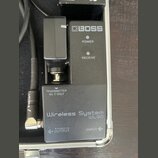 Černý bezdrátový přijímač s nápisy BOSS, POWER a RECEIVE. Na spodní části jsou texty TRANSMITTER WL-T ONLY, Wireless System WL-50 a značení OUTPUT a…