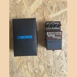 Kutý efekt pedál v hnědé barvě s nápisy DIRECT OUT, GUITAR IN, OUTPUT (MONO), BASS IN a označením SUPER Octave OC-3. Na horní části jsou ovládací prv…