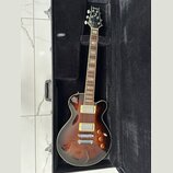 Elektrická kytara s trupem v tmavě hnědém sunburst provedení a krčkem z dřeva s vkládanými značkami poloh. Na hlavě je bílý nápis Dance a na hmatníku…