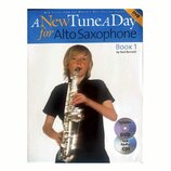 Fotografie zobrazuje obal učebnice s názvem A New Tune A Day for Alto Saxophone Book 1 by Ned Bennett. Na obálce je vyobrazen chlapec v černém tričku…