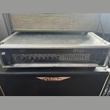 Černý kytarový zesilovač Ampeg SVT-3 PRO umístěný v transportním flightcasu s hliníkovými hranami. Na předním panelu jsou ovládací knoflíky a posuvní…
