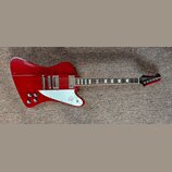 Červená elektrická kytara s bílým pickguardem a dvěma humbuckery. Na hlavě hmatníku je viditelné logo Epiphone. Nástroj vykazuje známky používání v p…