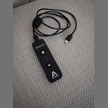 Černý přenosný audio rozhraní s připojeným kabelem USB-C. Na zařízení jsou bílé nápisy „Groove“ a „APOGEE“ spolu s logem značky. Uprostřed se nacháze…