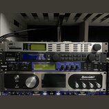 Snímek zachycuje čtyři rackové studiové procesory naskládané nad sebou. Horní zařízení je stříbrné s nápisem tc electronic a modrým logem. Druhý přís…