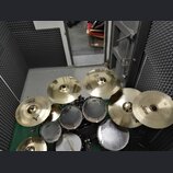 Sada cymbálů a bubnů v zeleném provedení. Na cymbálech jsou viditelné nápisy SABIAN, Zildjian a Soultone. Bubny mají bílé koženky s logem Evans. Celý…