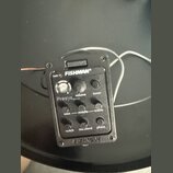 Černý plastový předzesilovač s integrovaným ladičkou a ovládacími prvky. Na zařízení jsou nápisy FISHMAN®, batt, volume, tuner, Presys blend, bass, m…