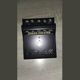 Černý kytarový efekt pedál s nápisy Gain, Bass, Contour, Treble a Volume. Uprostřed je velký bílý nápis SHRED MASTER a ve spodní části vy embossed lo…