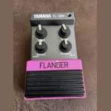 Kytarový efekt pedál v černé barvě s růžovým spodním panelem a černým gumovým šlapadlem. Na horní části je bílý nápis YAMAHA FL-10M a ve spodní růžov…