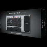 Fotografie znázorňuje krabici s vokálním procesorem Zoom V6-SP. Na krabici jsou nápisy ZOOM, V6-SP Vocal Processor a Take Control Of Your Vocal Perfo…
