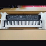 Černý digitální klavír v kartónovém balení s polystyrenovými výplněmi. Na levé straně korpusu je vidět nápis YAMAHA. Horní panel obsahuje řadu tlačít…