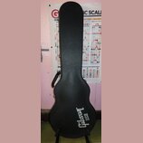 Černý tvrdý kufýr na kytaru s texturovaným povrchem. Ve spodní části je bílý nápis Gibson USA. Kufýr má připevněnou černou plastovou rukojeť a kovové…