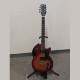 Elektrická kytara typu Les Paul v červenohnědé barvě s přechodem do tmavšího odstínu po okrajích. Na hlavě hmatníku je nápis Epiphone a pod ním kurzi…