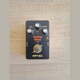 Černý efekt pedál s nápisy Analog Delay, SE-ADL a ARTEC. Obsahuje tři bílé ovládací knoflíky s popisky TIME, MIX a REPEAT. V dolní části je kruhové l…