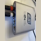 Stříbrný audio rozhraní s kovovým povrchem a logem esi a označením U24XL. Na levém boku jsou vstupy INPUT (L, R) a výstupy OUTPUT (L, R), do kterých…