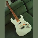 Bílá elektrická kytara s hnědým hmatníkem a bílým pickguardem. Na hlavě je viditelné logo "Squier". Nástroj má tři snímače, tři ovládací knoflíky a p…