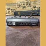 Zadní strana černého MIDI kontroléru s nápisem BEHRINGER B-CONTROL NANO. Na zařízení jsou vidět konektory AC INPUT, POWER a MIDI (OUT, IN), přepínač…