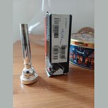 Stříbrný kovový moutur s rozšířenou základnou. Na spodní části je vyryt nápis „MADE IN JAPAN ALLEN“. Vedle nástroje je kartonová krabice s nápisy „TR…