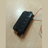 Černý humbucker snímač s plastovým krytem. Na horní části je bílý nápis EMG. Z boku vedou bílé a červené vodiče, spodní část vykazuje drobné známky o…