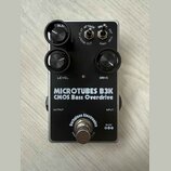 Černý efekt pedál s nápisy MICROTUBES B3K a CMOS Bass Overdrive. Na spodní části je logo Darkglass Electronics a označení napájení 9VDC. Pedál má dva…