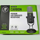 Fotografie znázorňuje krabici od mikrofonu s nápisy CARBON a PREMIUM USB CONDENSER MICROPHONE. Na obalu je zobrazen černý mikrofon s limegreenovým pr…