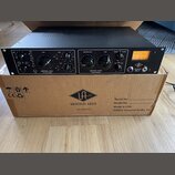 Černý rackový procesor s nápisem UNIVERSAL AUDIO LA-610 Mk II. Na předním panelu jsou ovládací knofíky, přepínače a VU metr s oranžovým podsvícením;…