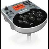 Stříbro-černý elektronický bicí modul s digitálním displejem a ovládacími tlačítky. Na horní části je nápis HDS240USB a logo behringer. Černý ovládac…