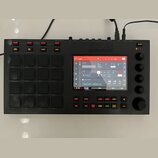 Černý samplingový kontrolér značky AKAI PROFESSIONAL s integrovaným barevným displejem. Zařízení obsahuje 16 gumových padů, několik ovládacích tlačít…