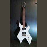 Bílá elektrická kytara s ostře hranatým tělem a černou hlavou. Na hlavě je bílý nápis BC Rich. Nástroj má dva humbuckery, chromovaný tremolo systém a…
