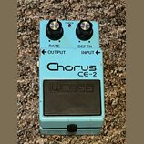 Světle modrý efekt pedál s nápisy RATE, DEPTH, OUTPUT a INPUT. Uprostřed je velký nápis Chorus CE-2 a ve spodní části černý spínací pedál s vyraženým…