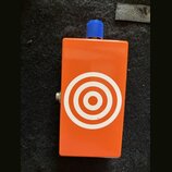 Oranžový efekt pedál s modrým ovládacím knoflíkem. Na přední straně je bílý grafický symbol v podobě soustředných kruhů (terč). Povrch je hladký, bez…
