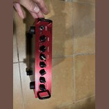 Červený basový zesilovač s nápisy THRUST a BQ500. Na předním panelu jsou ovládací knoflíky s popisky GAIN, THRUST, BASS, LO-MID, HI-MID, TREBLE a MAS…
