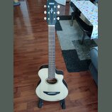 Akustická kytara s vyřezem v korpusu, světlým topem a černými hranami. Na hlavě hmatníku je bílý nápis YAMAHA a pod ním dekorativní ornament. Nástroj…
