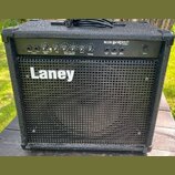 Černý kytarový kombo zesilovač s texturovaným povrchem a kovovou mřížkou reproduktoru. Na mřížce je bílý nápis Laney a v horní části ovládací panel s…